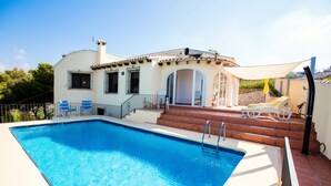 A swimming pool with a white house in the background. - Villa Cezanne, Sea Views, private pool, breezes, WIFI, close to new ALDI (Moraira-Teulada)
