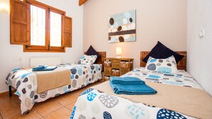 A bedroom with two beds, a wooden dresser, a nightstand, and a wall-mounted lamp. - Villa Cezanne, Sea Views, private pool, breezes, WIFI, close to new ALDI (Moraira-Teulada)