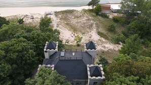 A coastal property with a large house featuring a prominent tower and a spacious deck.