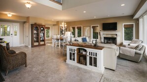 A spacious living room with a fireplace, a dining area, and a large window.