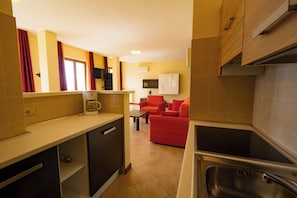 A compact kitchen with a built-in oven, a coffee maker, and a sink.