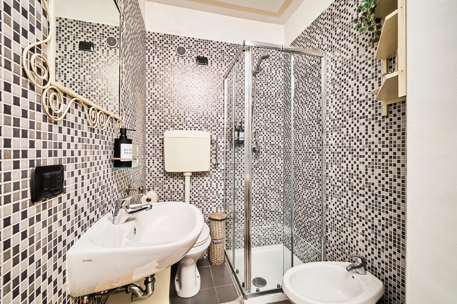 A bathroom with a shower, two sinks, and a toilet.
