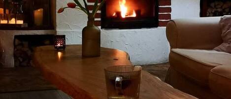 Una sala acogedora con chimenea de ladrillo, una mesa de centro de madera y un sofá.