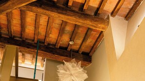 Una habitación con techo de madera, un adorno de papel blanco y un cuadro enmarcado en la pared.