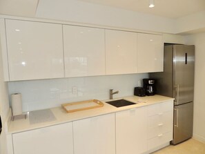 Køleskab, kaffe-/temaskine, højstol, køkkentøj/tallerkener/redskaber