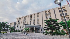 A hotel with a modern facade, multiple balconies, and a covered entrance area. - White Stones Hotel (Port Harcourt)