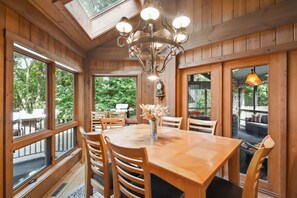 A wooden interior with a large dining table, chairs, and a chandelier. - Galena Getaway w/ Hot Tub, Home Theater & More! (Galena)