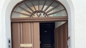 A brown door with a nameplate, a keypad, and a small window with a decorative frame. - PROMOTION "TOURISTHOUSE MONOPOLI 10" ROOM1 TRIPLE WITH EN SUITE BATHROOM (MONOPOLI)