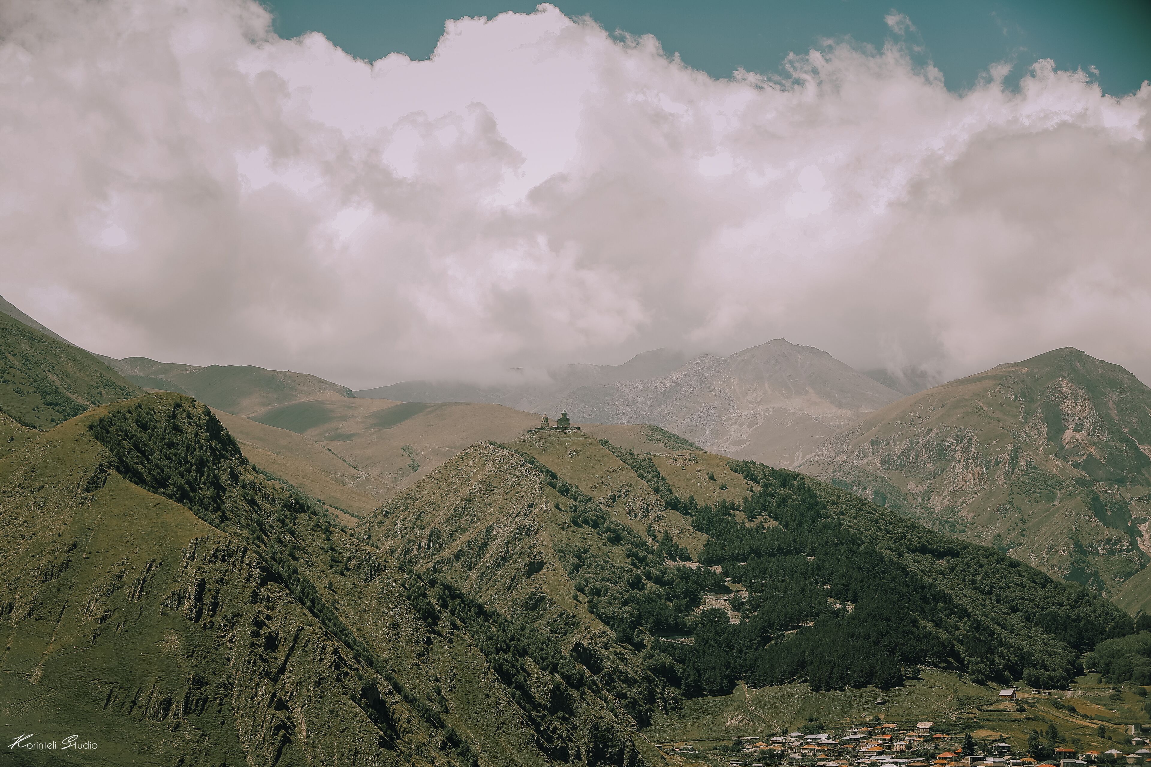 A mountainous landscape with a small settlement nestled among the hills.