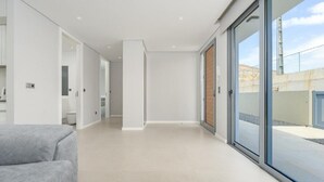 En rummelig, moderne indretning med en stor skydedør, der fører ud til et udendørs område.