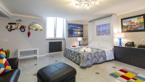 A modern bedroom with a bed, a desk, a chair, and a sofa. - Modern apartment in Chiaia on two levels with panoramic terrace (Napoli)