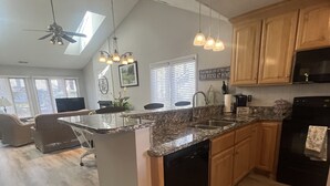A modern kitchen with a granite countertop, wooden cabinets, and a built-in dishwasher. - Beautiful Lakeside Condo/The Maples Golf Course On Site/Golf Haven/Near Pinehurst & Southern Pines/40 Golf courses minutes awaySleeps 9 (Vass)