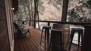 Une terrasse en bois avec des sièges extérieurs et une vue sur un paysage vallonné.