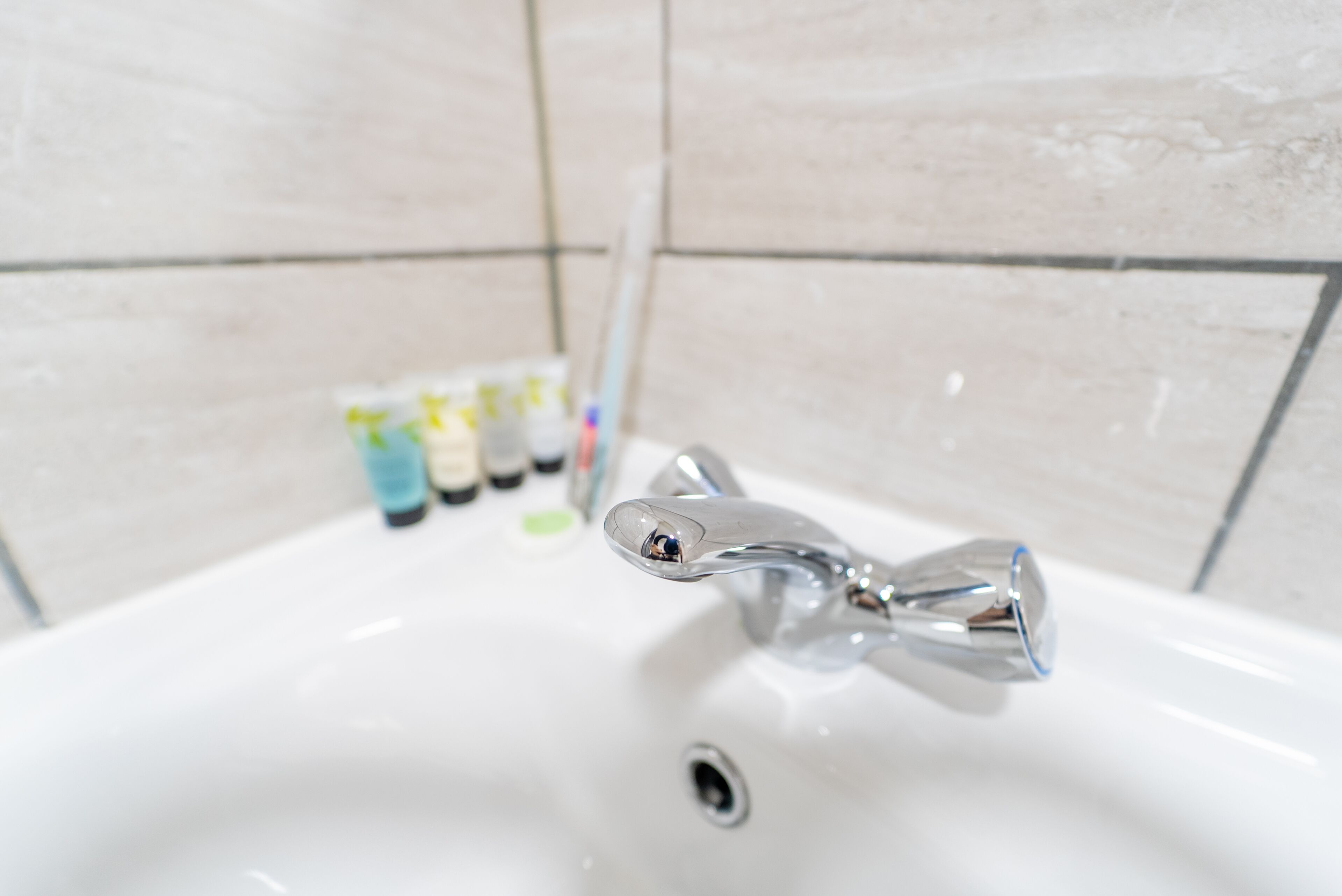 Un lavamanos de baño con un grifo cromado y desagüe.