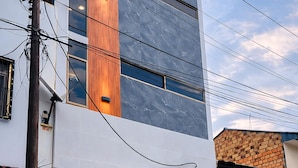 A modern building with a stone facade, a wooden accent column, and a number '512' sign. - Bellazio Aparthotel (Iquitos)
