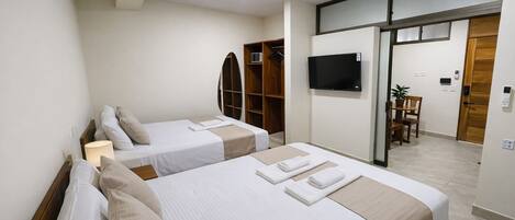 Une chambre d’hôtel avec deux lits, une télévision, un bureau et une armoire.
