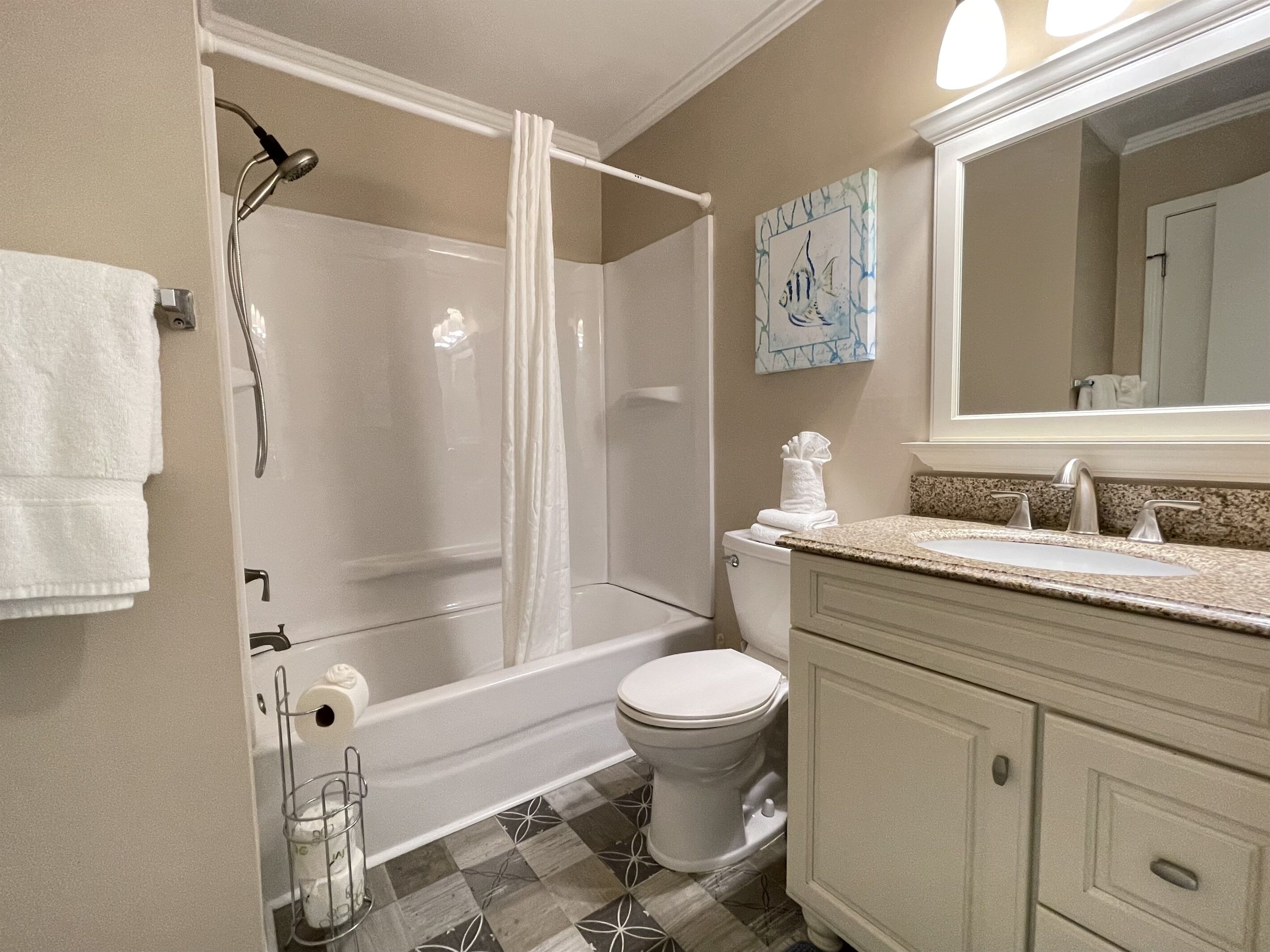 Une salle de bain avec douche, toilettes et lavabo.