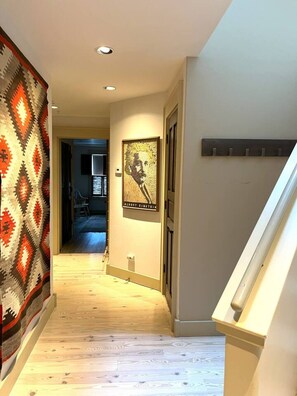 A hallway with a patterned carpet, a framed artwork, and a staircase. - Penthouse #2 at DiamondTooth - location and views! (Telluride)