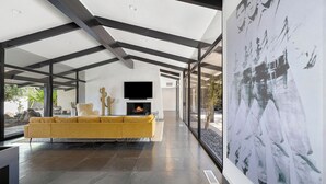 Un salon moderne avec un grand canapé, un téléviseur à écran plat et une cheminée.