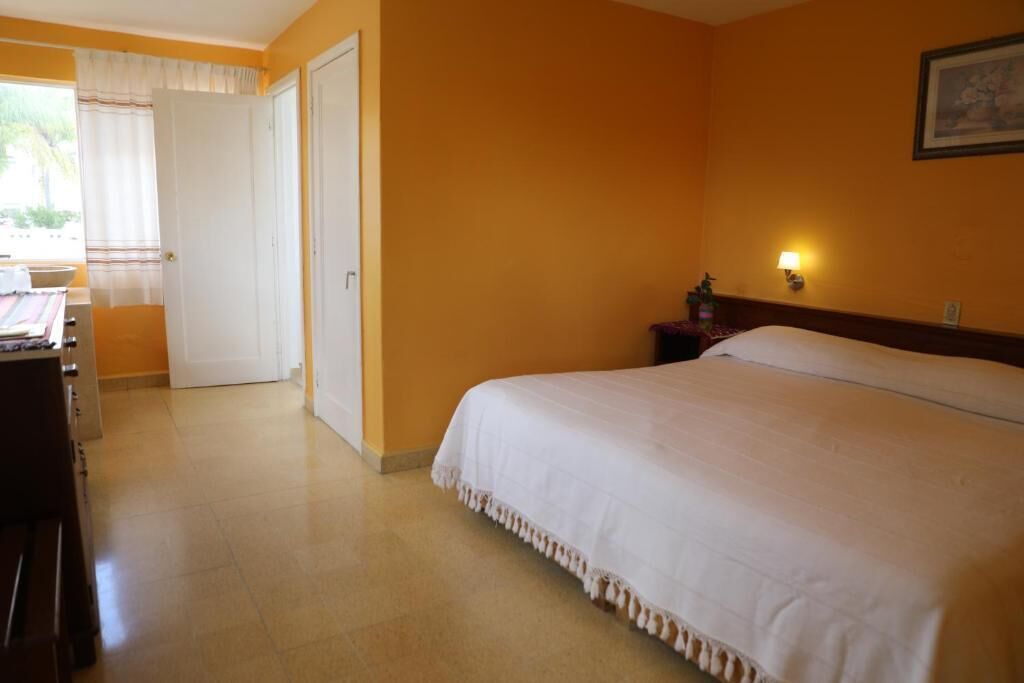 Una habitación de hotel con una cama, un escritorio y una silla.