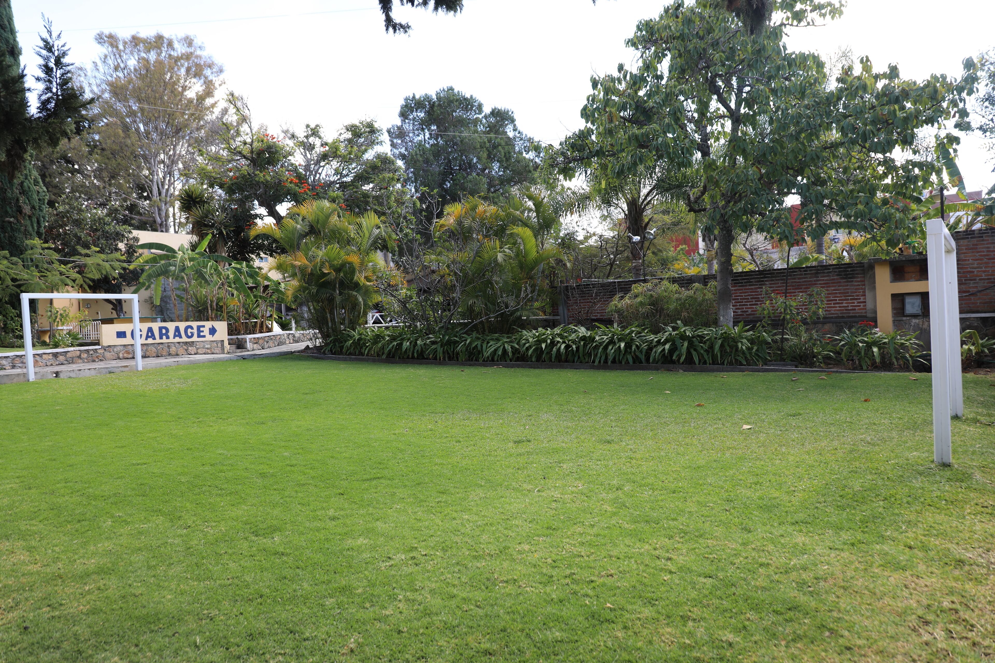 A grassy area with a sign indicating a garage.