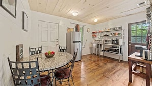 A kitchen with a granite countertop, stainless steel appliances, and a 'CHEERS' sign on the wall.