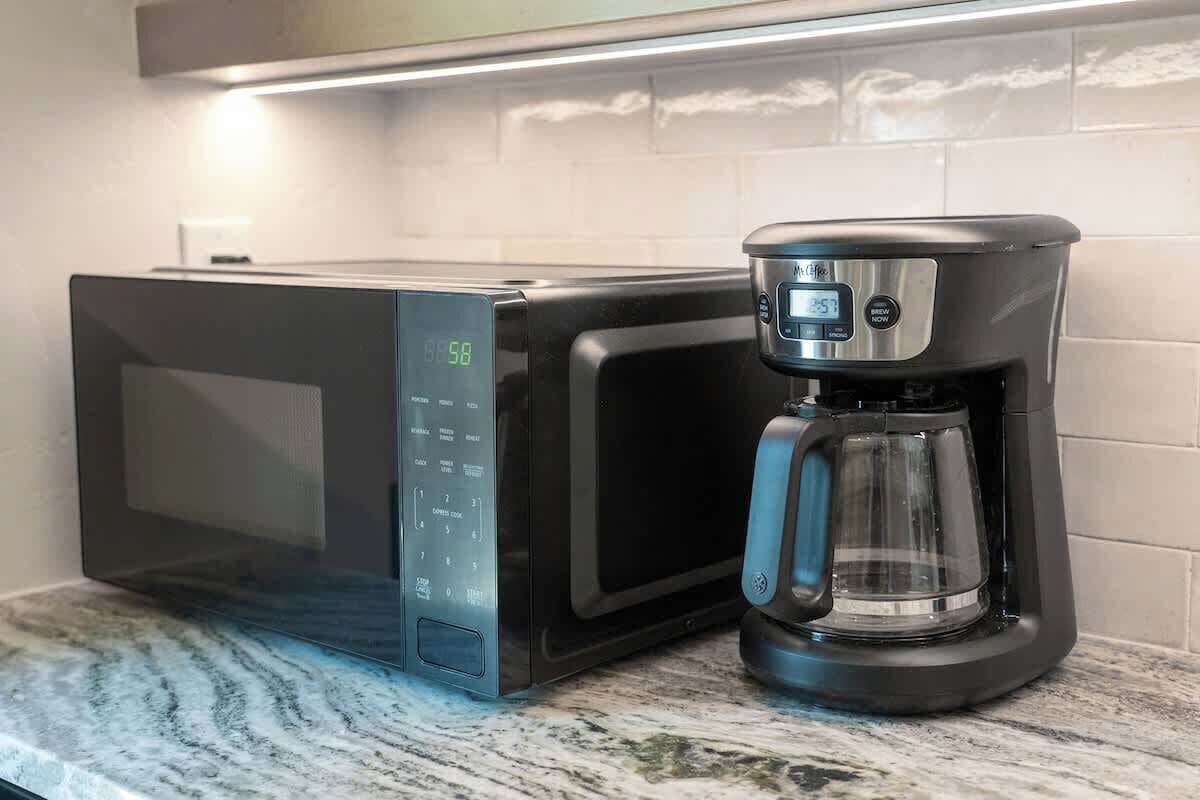A microwave and coffee maker on a kitchen counter.