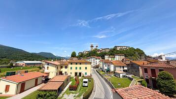 A town with buildings, a road, and a hill with a tower.
