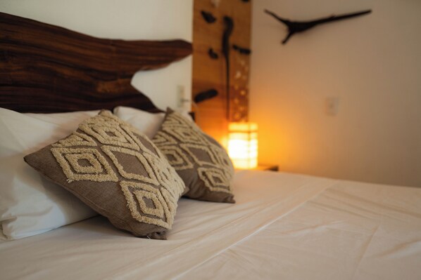 A bed with patterned pillows and a wooden headboard.