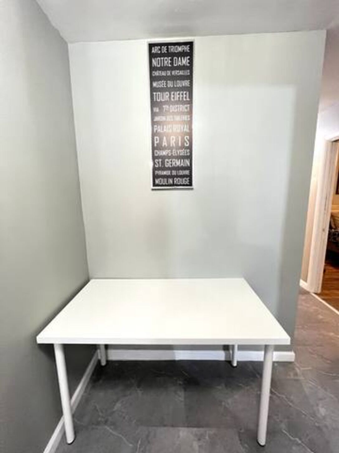 A white table with a black sign listing Paris landmarks.