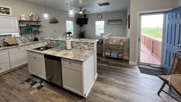 A modern kitchen with a central island, built-in appliances, and a dining area with a view.
