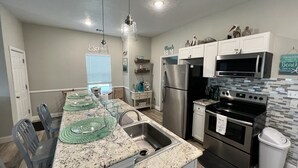 A modern kitchen with granite countertops, stainless steel appliances, and a breakfast bar.
