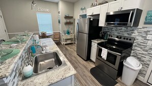 A modern kitchen with granite countertops, stainless steel appliances, and a black oven.