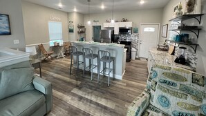 A modern kitchen with a central island, built-in appliances, and a dining area with a sofa and chairs.