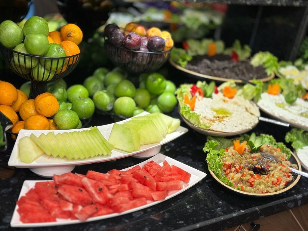 A buffet with various fruits and salads.