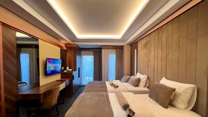 Une chambre d’hôtel avec un grand lit, un bureau, une télévision et une vue sur l’extérieur.