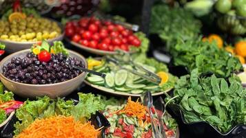 A variety of fresh vegetables and salads displayed in bowls and plates.