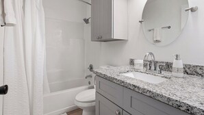 A bathroom with a shower, toilet, sink, and mirror. - The Secret Bayou Retreat to Rest and Unwind - HAR1 (Iowa)