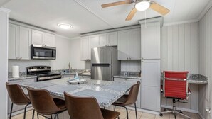 A kitchen with white cabinets, stainless steel appliances, a granite countertop, and a ceiling fan. - The Secret Bayou Retreat to Rest and Unwind - HAR1 (Iowa)
