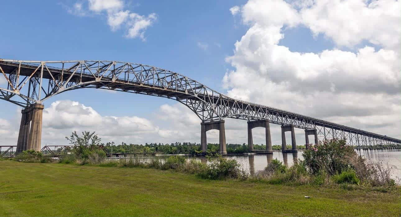 A steel bridge with multiple supports over a body of water.