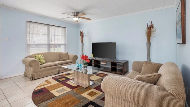 A living room with two sofas, a coffee table, a flat-screen TV, and a ceiling fan. - The Secret Bayou Retreat to Rest and Unwind - HAR1 (Iowa)