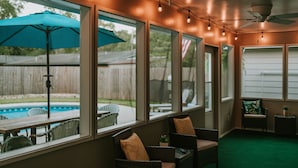 A covered patio area with wicker furniture, a pool, and a ceiling fan. - 4BR/3BA w/POOL in golf cart district near the Beach - Shadowlawn (Ocean Springs)