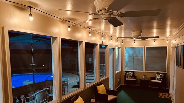 A room with a pool, multiple windows, ceiling fans, and string lights. - 4BR/3BA w/POOL in golf cart district near the Beach - Shadowlawn (Ocean Springs)