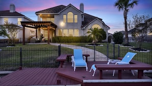 A house with a deck, outdoor seating, and a well-maintained lawn. -  truly stunning lakefront with immediate access to all the city has to offer. (Cypress)