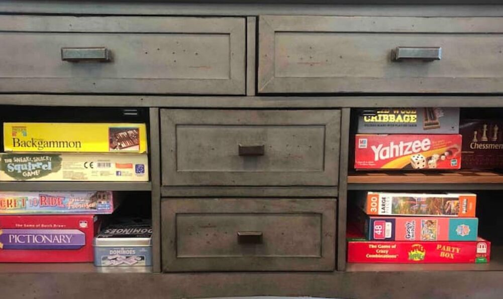 A storage unit with multiple compartments, each containing various board games and boxes.