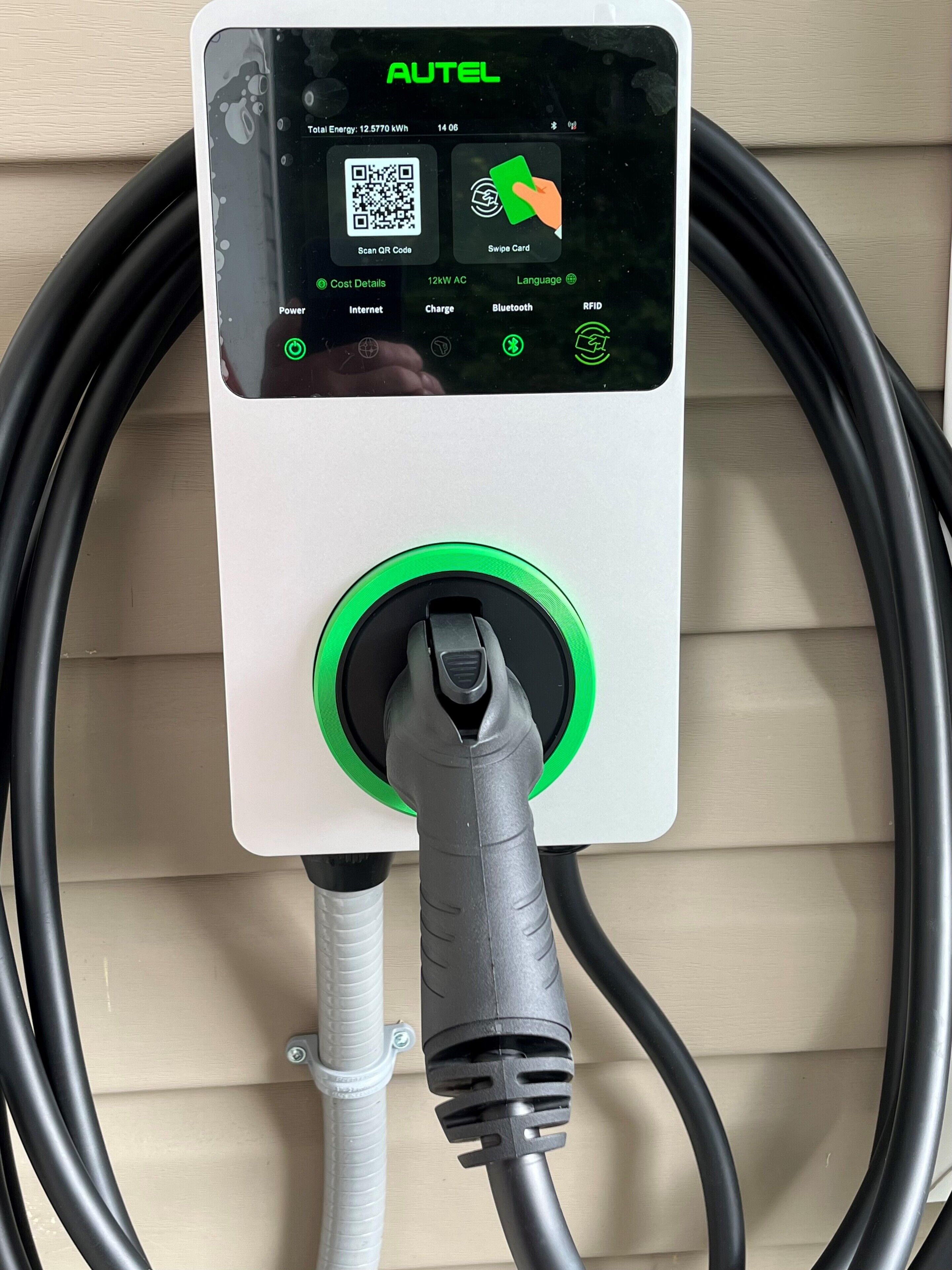 An AUTEL charging station with a digital display, QR code, and card swipe interface, connected to a cable.