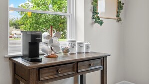 Un comptoir de cuisine avec une machine à café, des théières et des tasses.