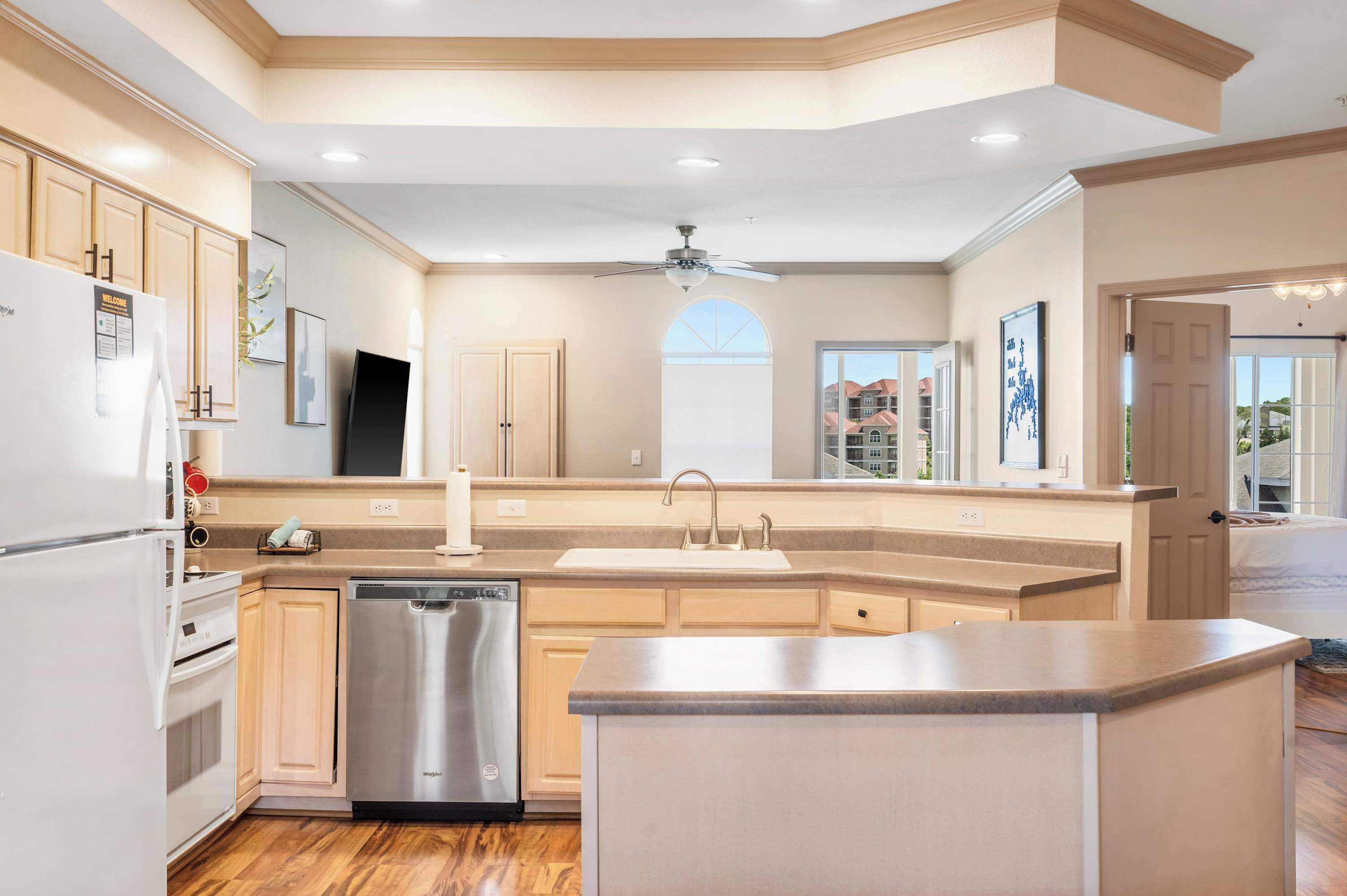 A modern kitchen with built-in appliances, a central island, and a view of the city.