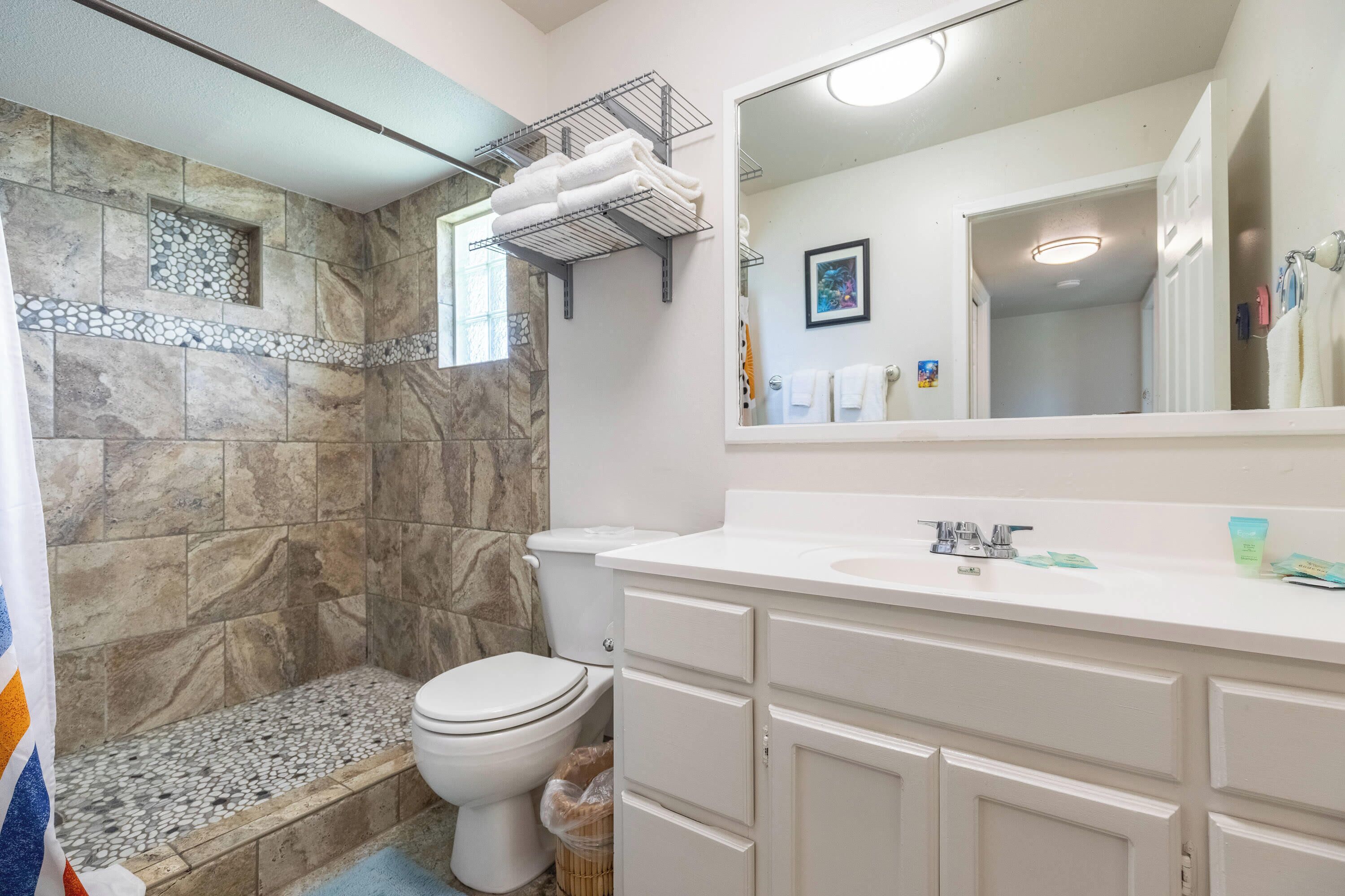 A bathroom with a shower, toilet, and sink.