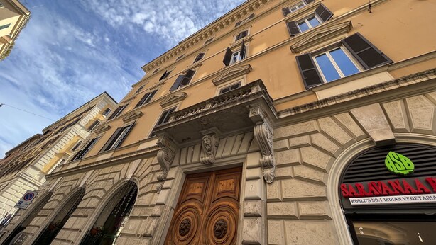 A building with a prominent entrance, a sign for Saravana App, and classical architectural details. - Camere con vista sul Chiostro Di Michelangelo (Rome)